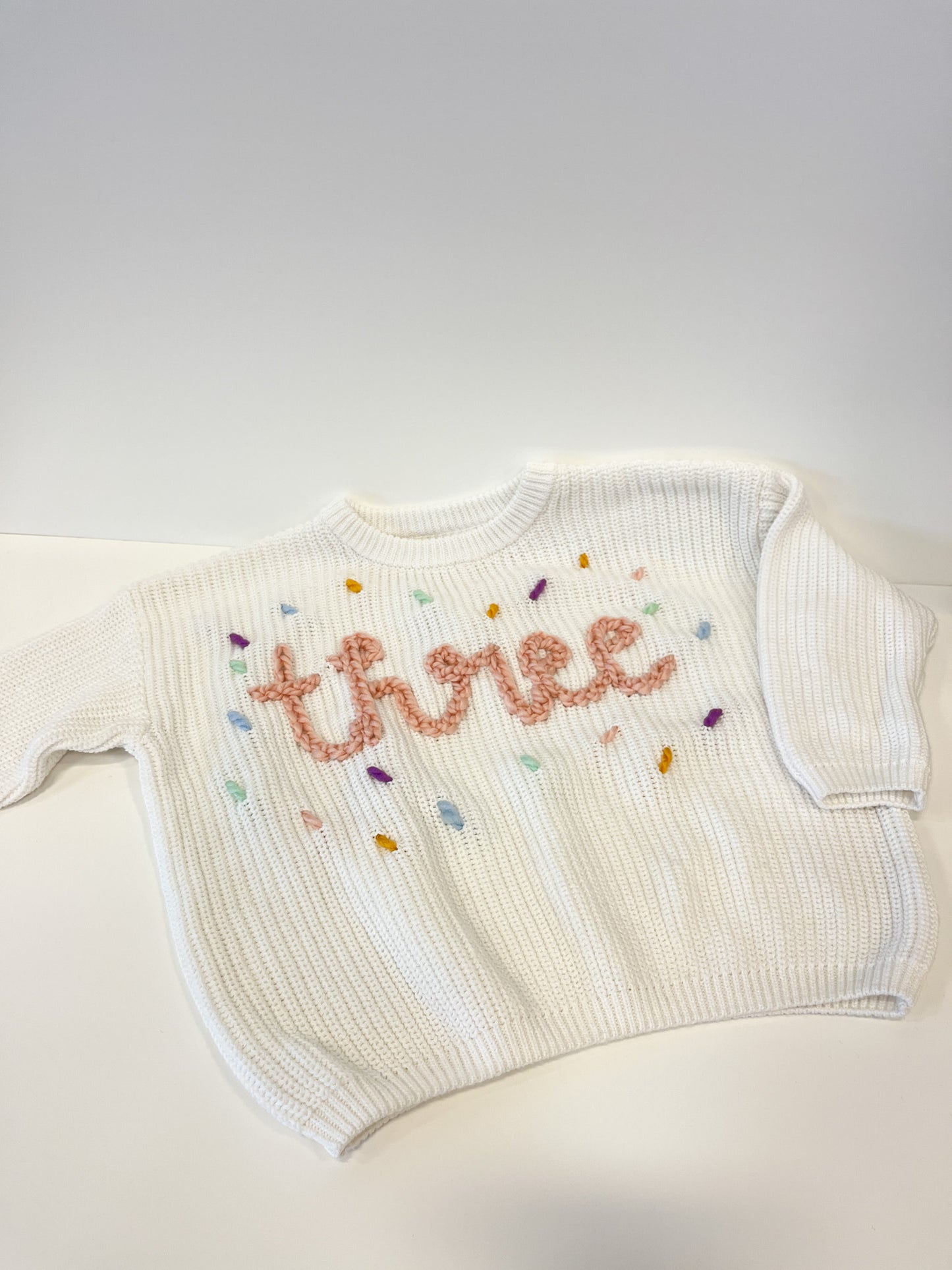 "Three" Embroidered Knit Sweater