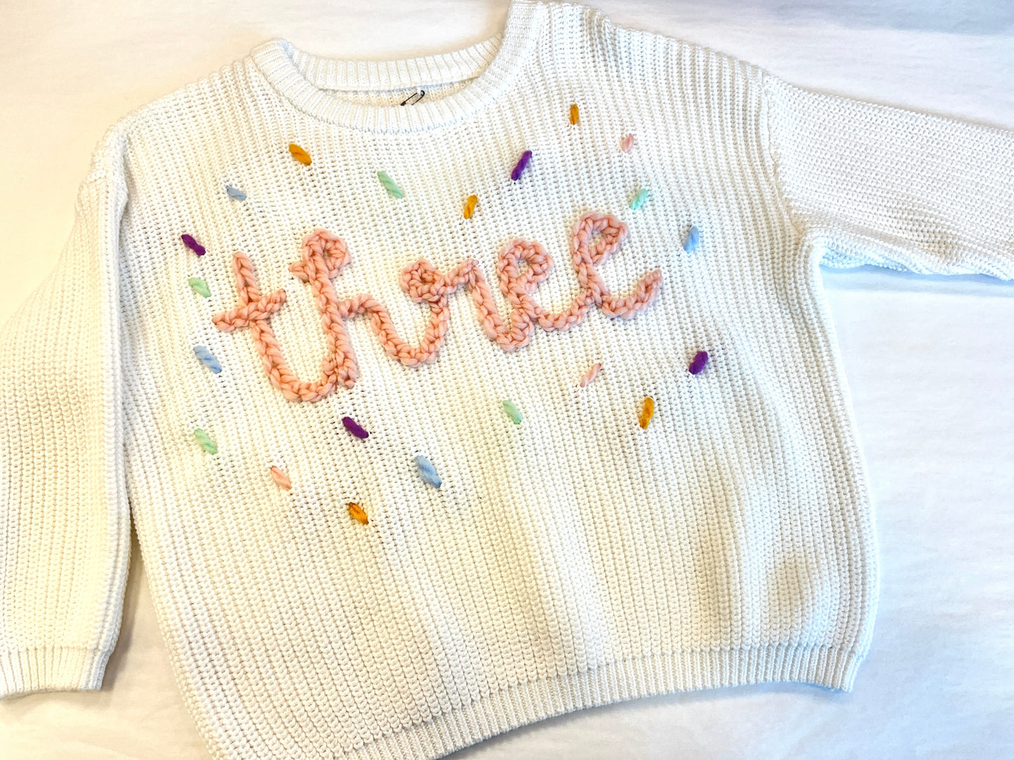 "Three" Embroidered Knit Sweater